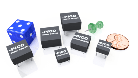 Electronic components with "PICO 38000 SERIES" labels are next to a blue die, green push pins, and a U.S. penny for scale.