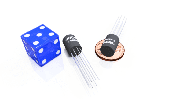 A blue six-sided die, two cylindrical electronic components with wires, and a penny arranged on a white surface.